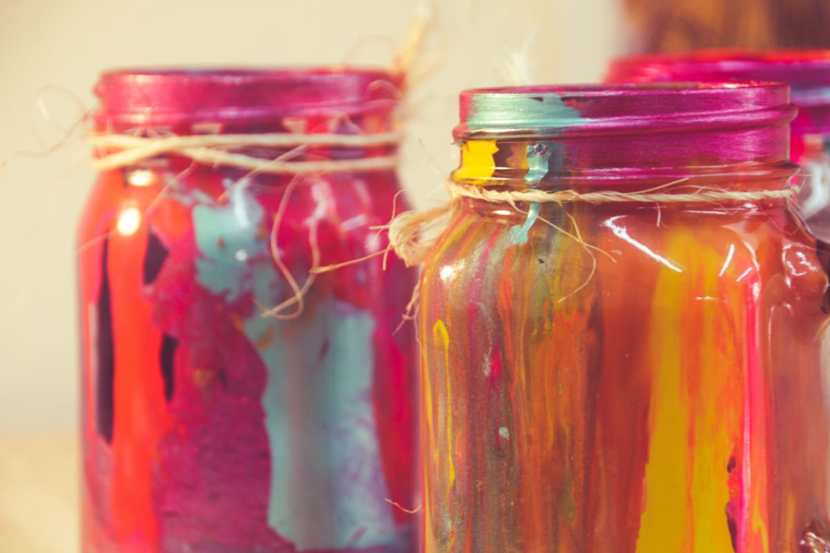 Close up of mason jars that are painted on the inside with different colors