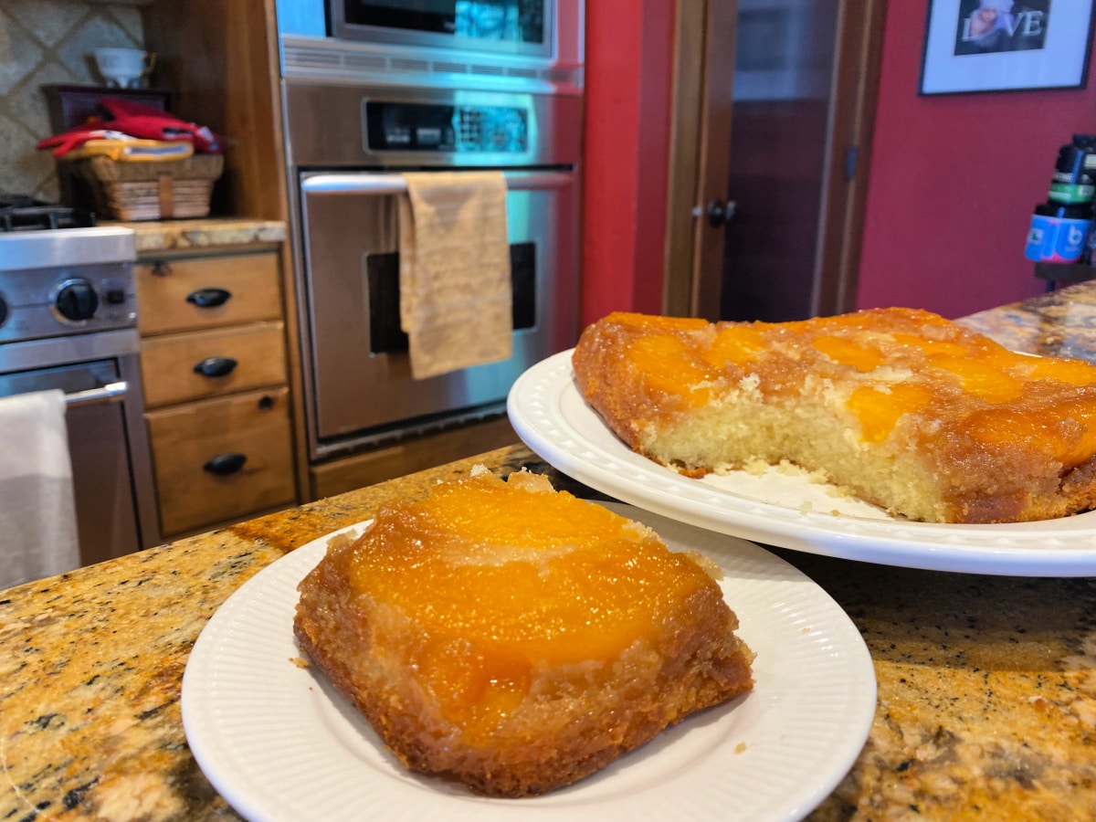 slice of peach cake by the cake pan