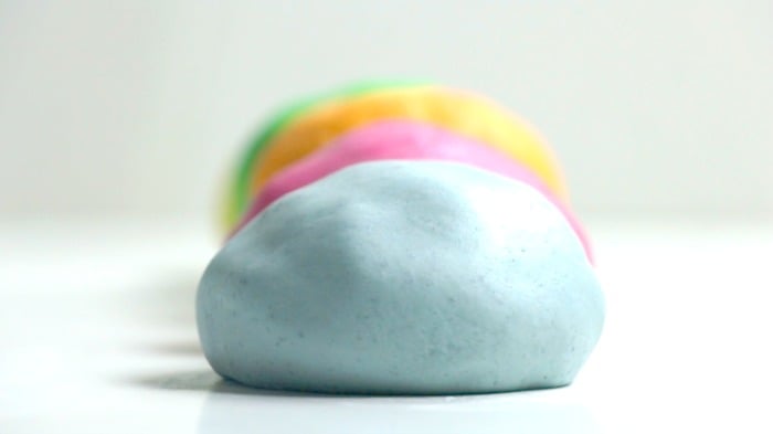 Homemade colorful clay on a white table.