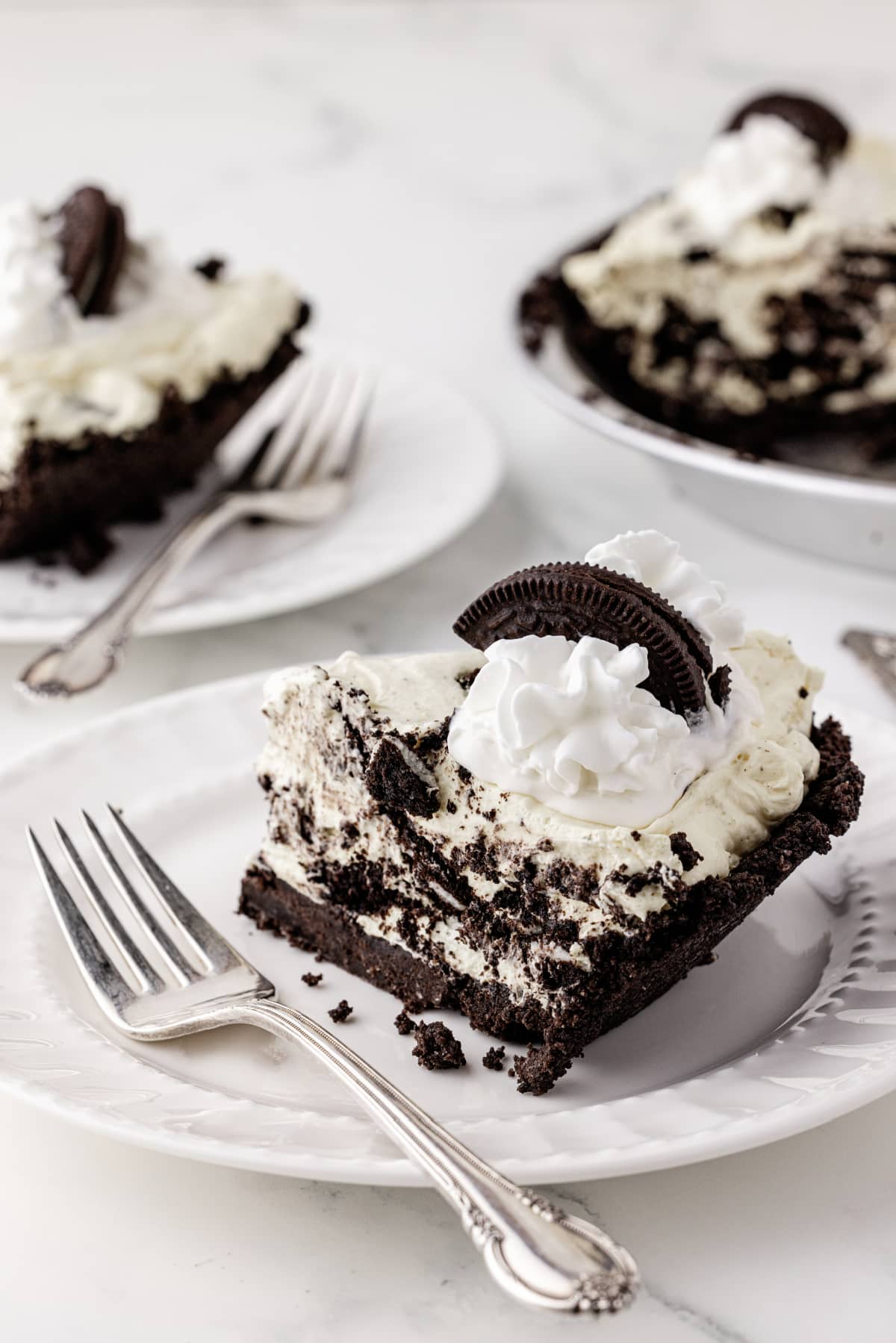 creamy Oreo pie on a white plate and white marble countertop