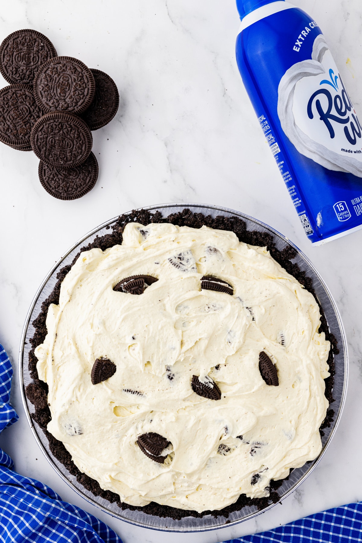 Oreo pie crust filled with filling and topped with Oreo cookies and Whipped Cream