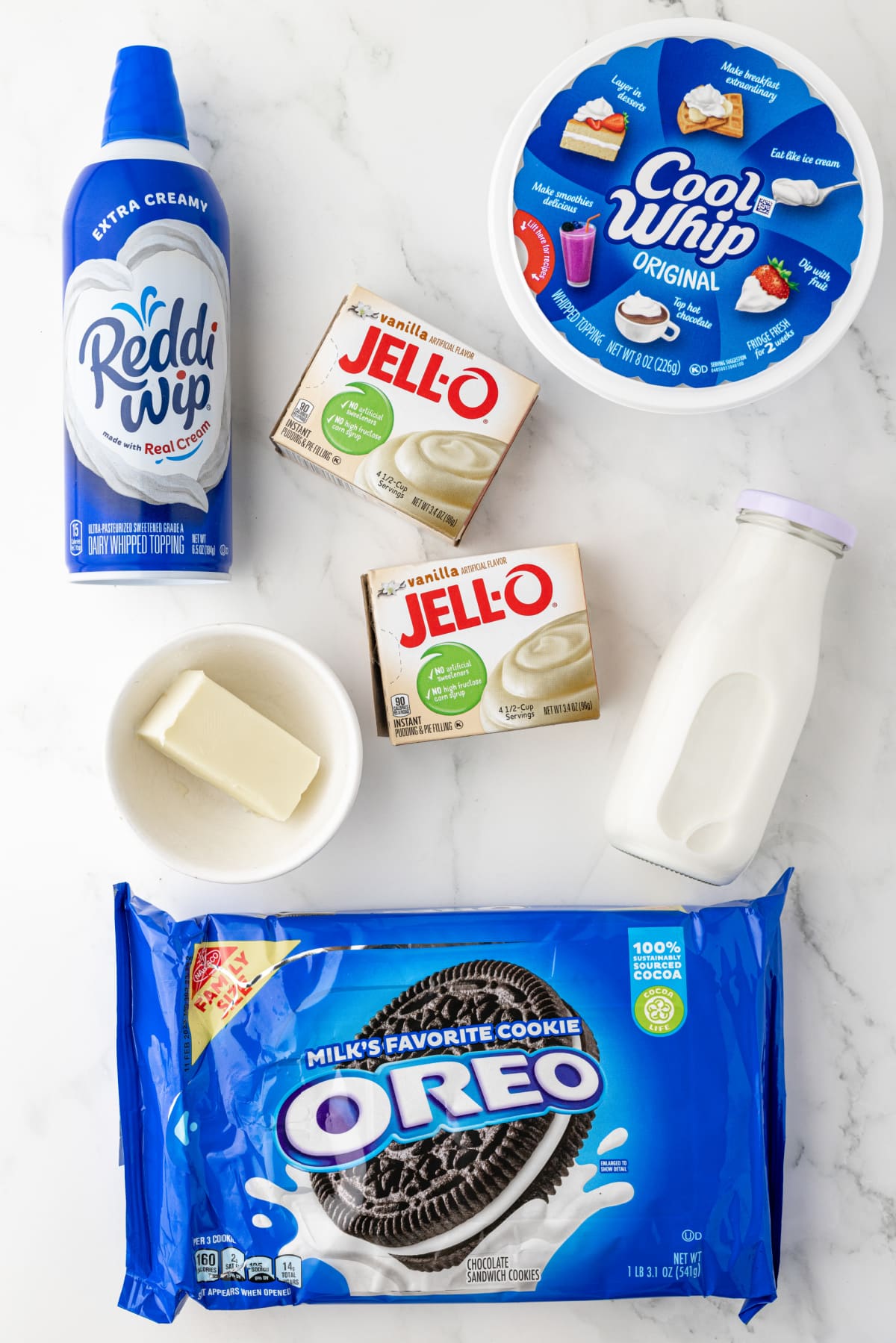 reddi whip, jell-o packets, cool whip and a box of Oreo cookies on a white countertop