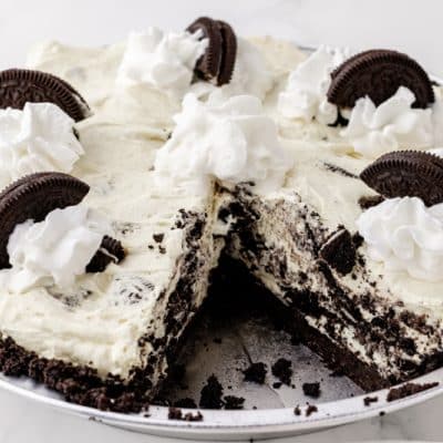 Chocolate and cream pie topped with Oreos and missing a slice