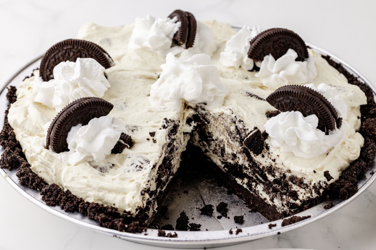 chocolate pie with cream filling that is topped with Oreos and missing a slice