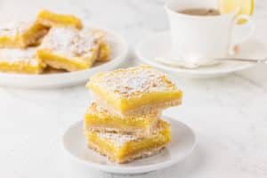 white plate with 3 stacked lemon bar cookies