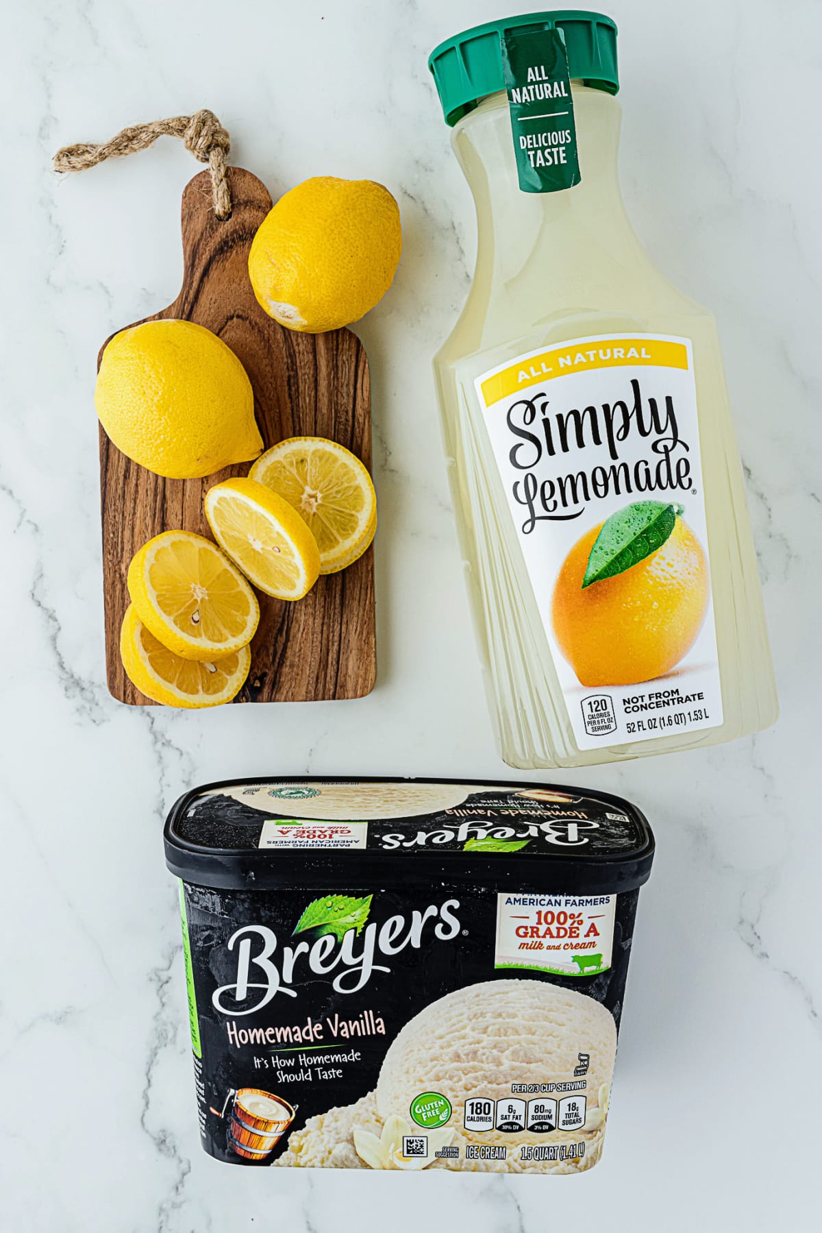 lemons on a wooden cutting board with Simply Lemonade and a carton of Breyer's Vanilla Ice Cream