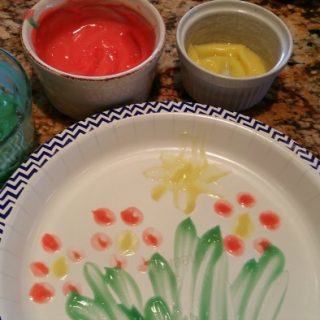 paper plate with flower designs made out of edible finger prints