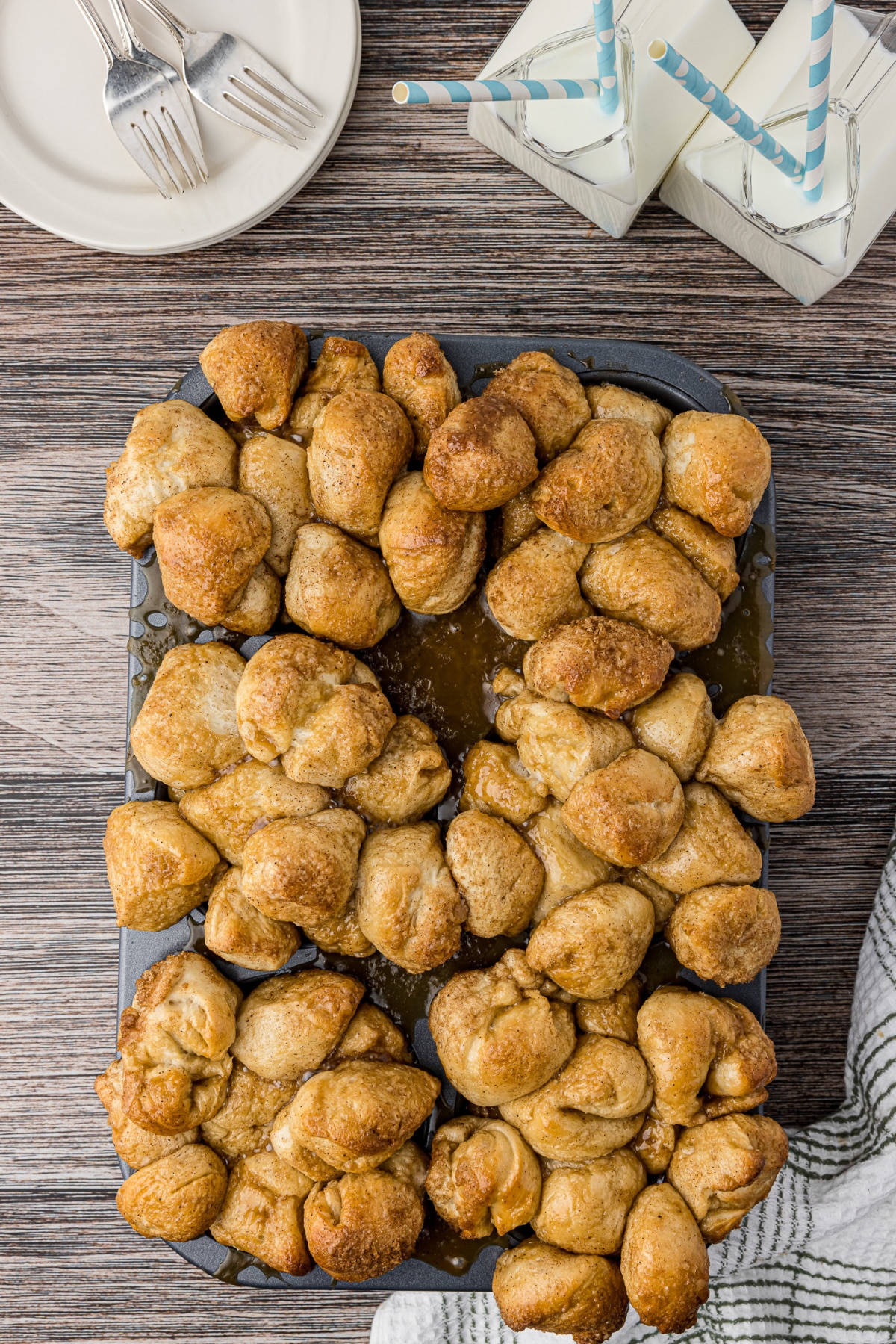 monkey bread baked in muffin tins on wooden table with butter and sugar