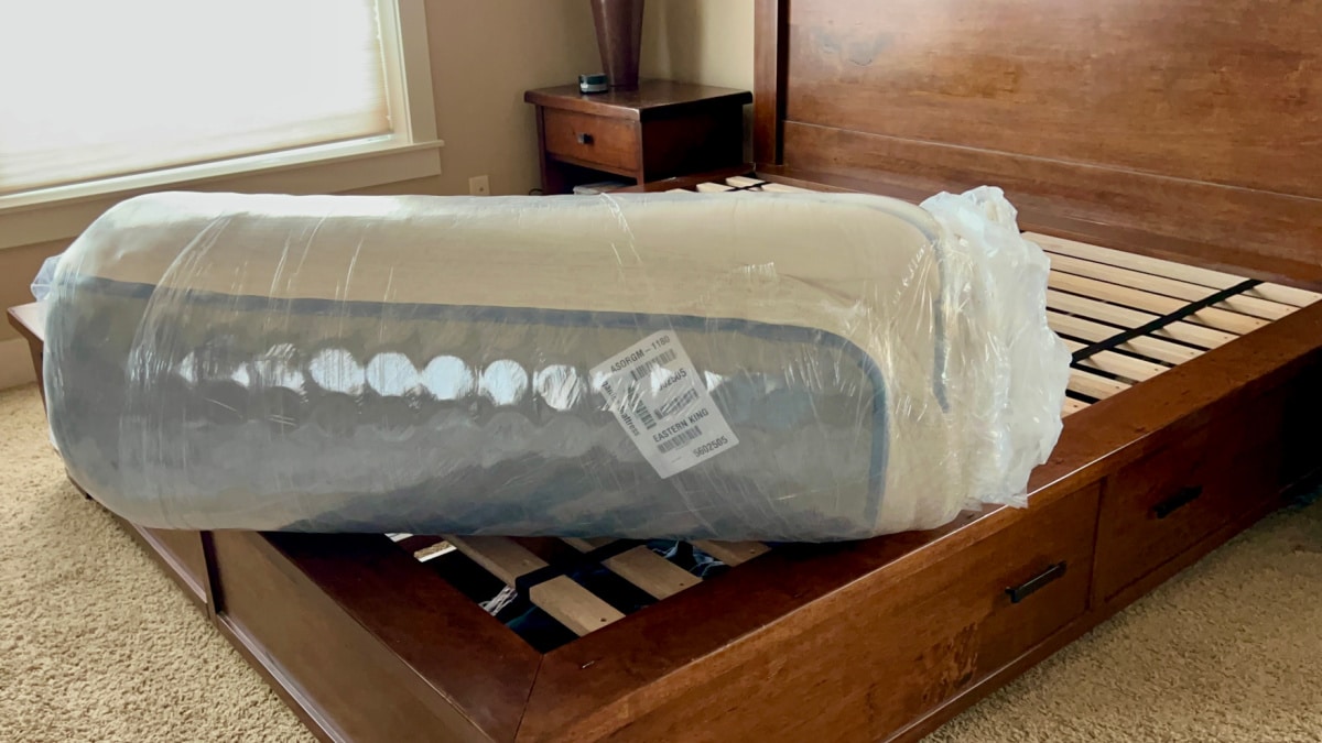 Amerisleep mattress rolled up in plastic prior to expanding