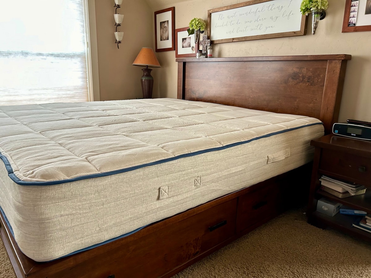 King sized Amerisleep mattress sitting on a dark wood farmhouse bed frame from PotteryBarn