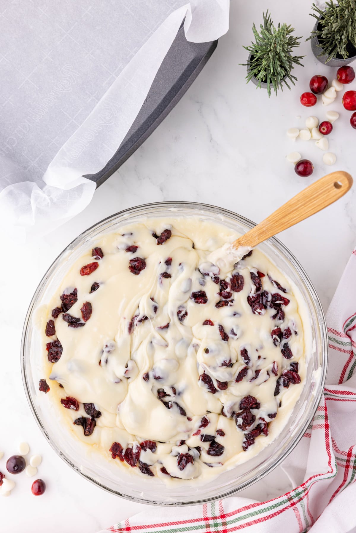 Dried cranberries being mixed into melted white chocolate 