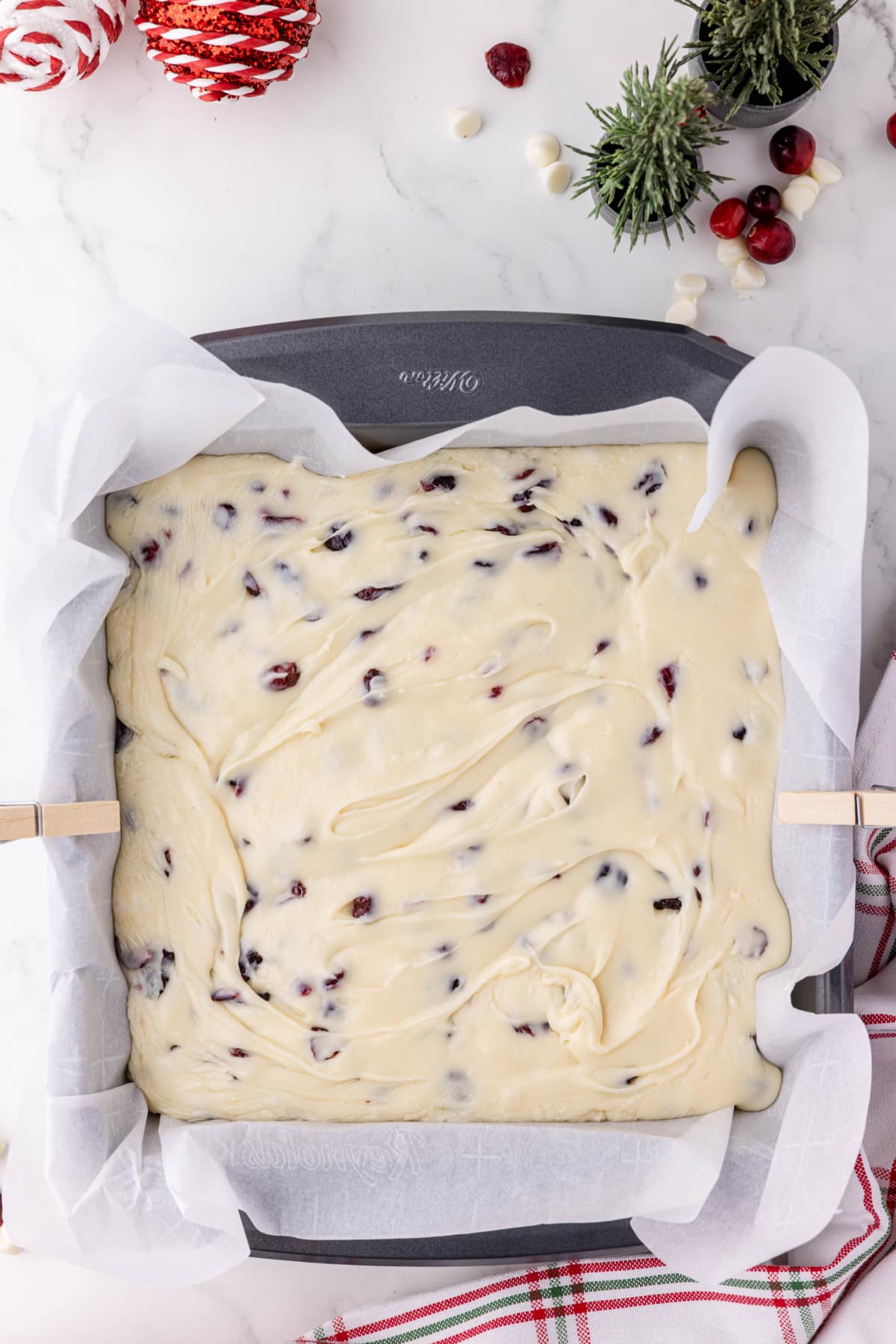 white chocolate fudge setting up in a baking pan with parchment paper