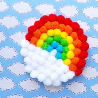 Rainbow made of pom poms sitting on a cloud wallpaper background