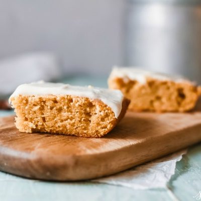 slices of pumpkin cake on a bread board with light blue table cloth