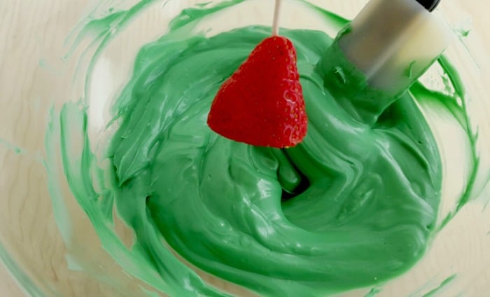 Dipping Strawberries in Green Chocolate to make Christmas Trees