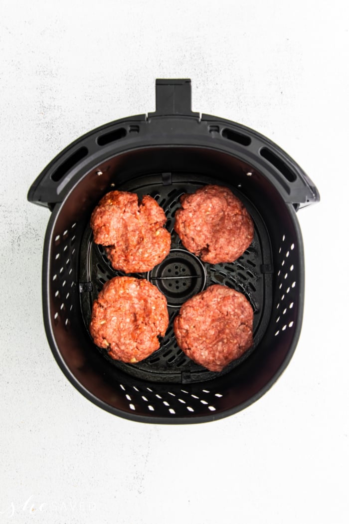 Four ground beef burger patties in the air fryer