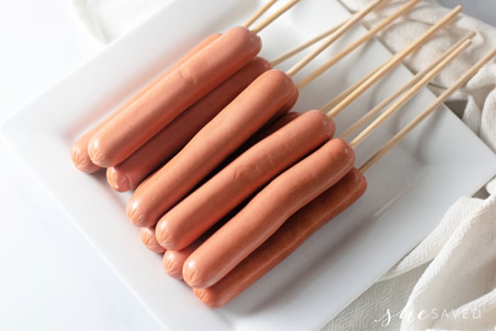 hotdogs on sticks for corn dog batter dipping