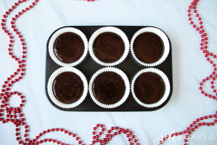 chocolate cupcake batter in a muffin tin with liners
