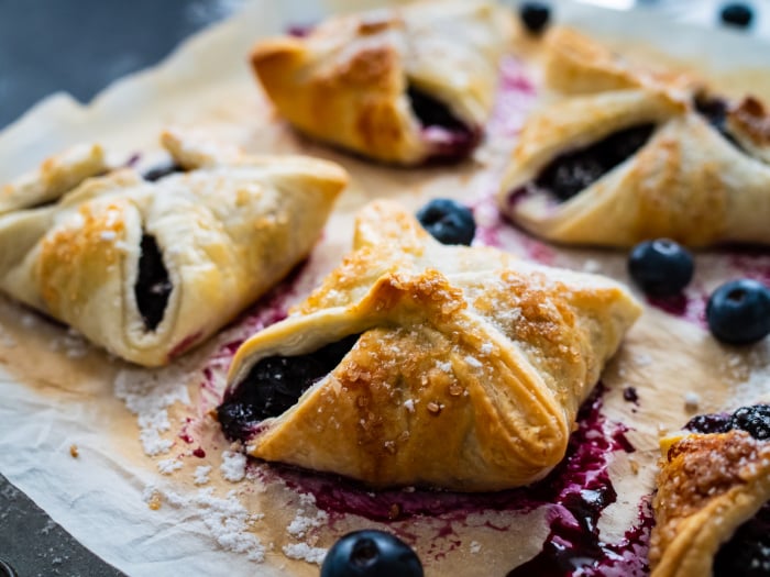 Blueberry Puff Pastry on Parchment Paper with Blueberries and juice 