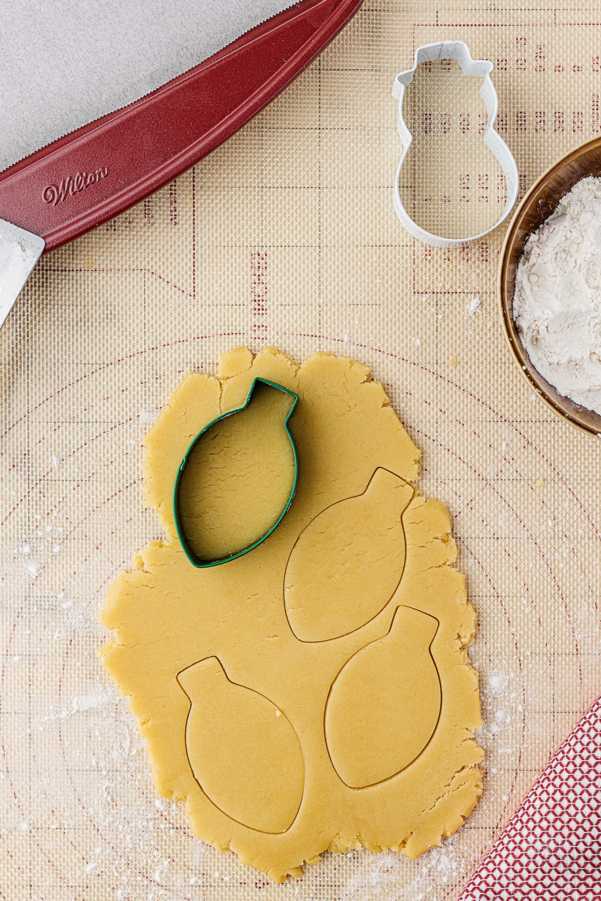 christmas bulb shaped cookie cutter in sugar cookie dough