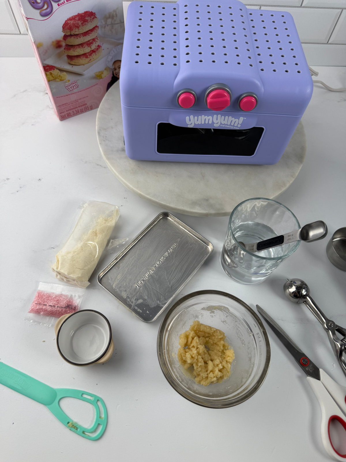 Yum Yum easy bake oven with accessories laid out on a counter